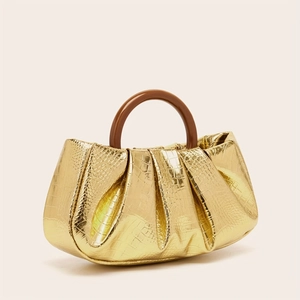 Detail of gold crocodile texture evening bag with ruched design and brown round handle