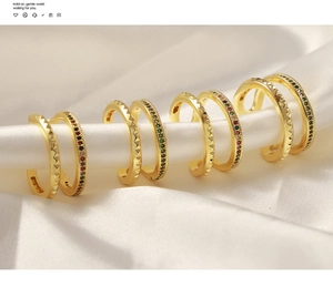 Detailed display of gold hoop earrings with textured surfaces and vibrant colored gemstones