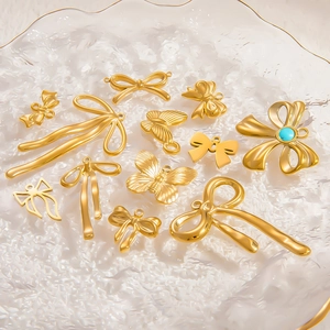 Golden stainless steel butterfly and bow charms with turquoise stone on water texture background