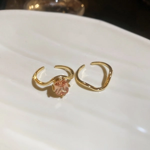 Macro shot of 18k gold plated champagne zircon stackable wave rings on a white dish