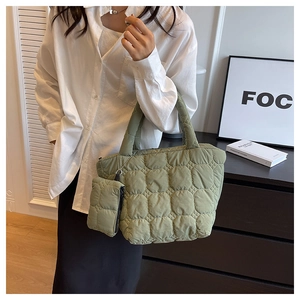 Detail view of grass green quilted nylon tote bag with matching mini coin pouch on handle
