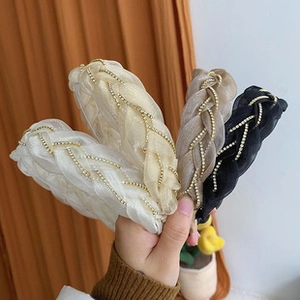 Detail of four woven organza headbands with faux pearls in white, gold, and black