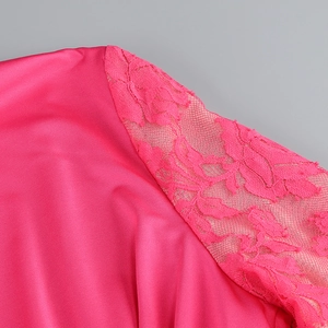 Detail of rose pink satin dress featuring elegant lace patchwork and smooth fabric texture