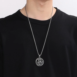 Gros plan détaillé d'un pendentif dragon en argent sur une chaîne avec fond noir