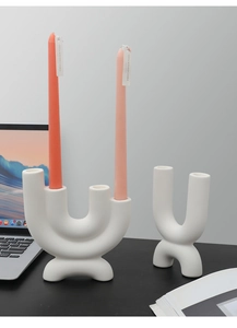 Detailed view of matte white geometric ceramic candle holders in U-shaped minimalist design