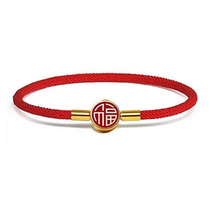 Dettaglio del bracciale in corda rossa intrecciata con ciondolo Fu dorato e chiusura