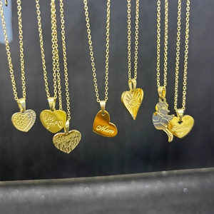 Close-up of gold heart necklaces with engraved love and mom messages on dark background