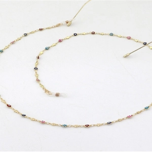 Fashionable gold glasses chain with colorful evil eyes and stars on a white background