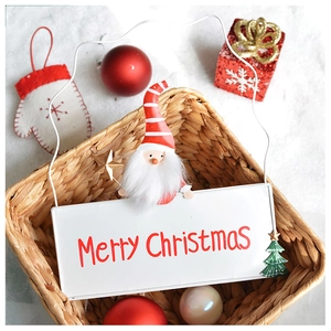 Close-up of Merry Christmas metal sign with Santa and tree motifs in a festive basket