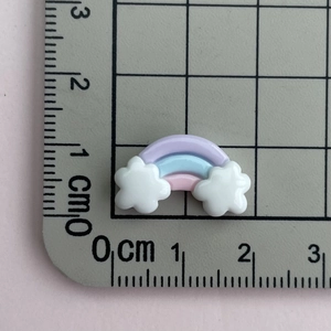 Detailed size reference of 2cm resin rainbow cloud charms on a measuring grid scale