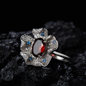 Macro shot of S925 silver floral ring with garnet and tiny colorful gemstones