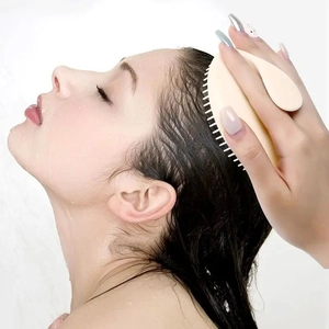Scalp massager brush for hair washing in beige silicone shown in a shower setting