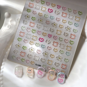 Macro shot of 3D embossed bear and heart nail stickers with jelly candy colors