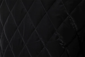 Macro detail of black diamond-quilted jacket fabric with fine woven texture and stitching