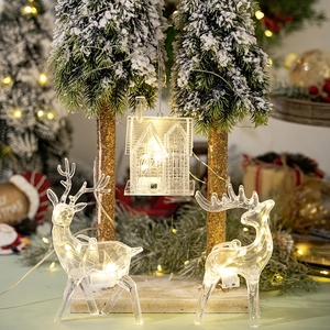 Christmas LED acrylic deer and house ornaments in a warm snowy forest scene