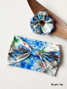 Floral butterfly printed yoga headband and matching scrunchie set on a wooden tray
