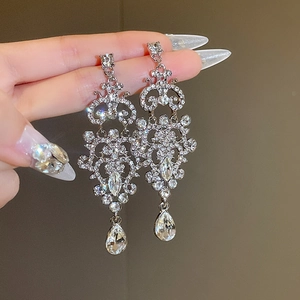 Detail of silver droplet drop earrings with sparkling rhinestones in Baroque design