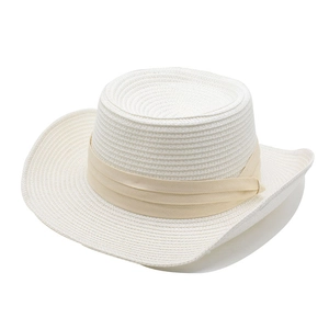 Close-up of a white woven straw hat with elegant beige silk ribbon and side knot detail