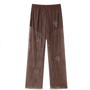 Détails de paillettes étoilées et perles sur le pantalon large en tulle marron transparent