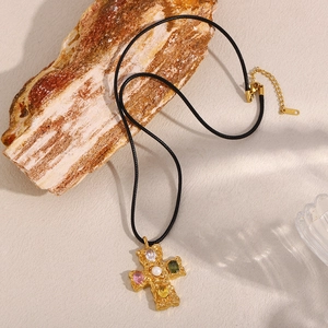 Macro view of 18K gold-plated cross pendant with colorful gemstones and 18KGP mark