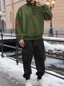 Dettaglio della felpa in maglia a nido d'ape verde con toppe marroni e pantaloni cargo