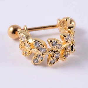 Close-up of golden leaf-shaped cartilage earring with zircon stones and screw ball back