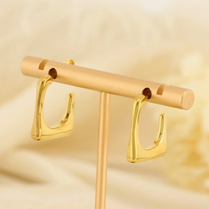 French vintage gold U-shaped geometric earrings displayed on a minimalist jewelry stand