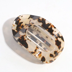 Macro detail of oval leopard print hair clip in brown tortoise shell acetate finish