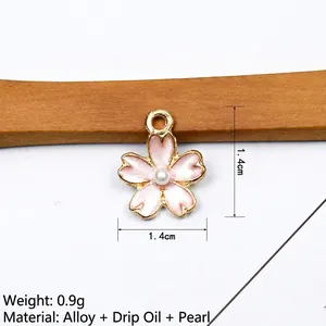 Macro detail of a 1.4cm pink enamel cherry blossom charm with pearl inlay and alloy base