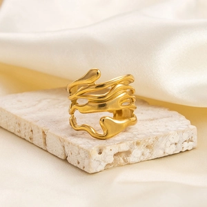 Detailed view of an irregular 18K gold-plated stainless steel ring on a stone tray