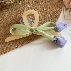 Detail of tulip hair claw clip with green silk ribbon and purple fabric flowers