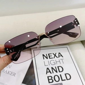 Close-up of rimless butterfly sunglasses with gradient purple lenses and metal bridge