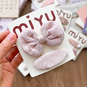 Pink fabric bow hair clip set for girls on miyu display card with soft knit texture