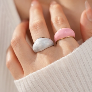 Detail of minimalist dome rings with white marble and vibrant pink enamel finishes