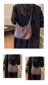 Detail of brown PU leather hobo bag with contrast stitching and silver metal chain strap