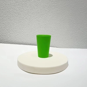 Detail of a solid green educational stacking cup on a clean white display stand