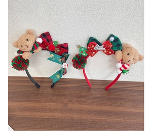 Detail view of two plush Christmas headbands with teddy bears and plaid bows