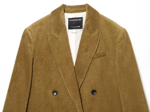Detailed view of tan corduroy blazer collar with branding and size tag details