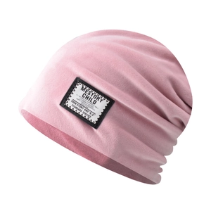 Close-up of pink chenille knit beanie showing vintage fabric patch and soft texture
