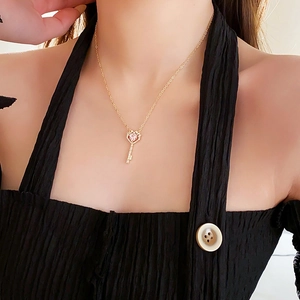 Nahaufnahme der vergoldeten Schlüsselkette mit rosa Herz-Edelstein an einem Modell
