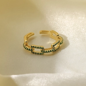 Macro detail of 18k gold plated chain ring featuring pavé-set green gemstones