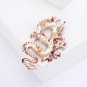 Detailed back view of a gold and red enamel dragon brooch showing the secure pin fastener