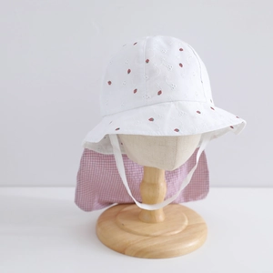 Détail de la broderie fraise et dentelle ajourée blanche sur le chapeau de soleil enfant