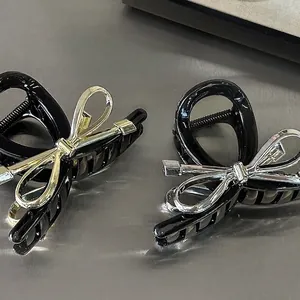 Elegant black bow hair claws with gold and silver metal accents for women's updos