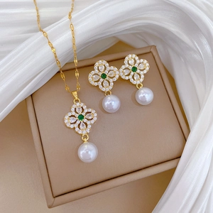 Luxury gold necklace and earrings set with green stones, zircons and white pearls