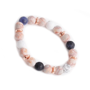 Dettaglio di bracciali in pietre naturali da 10mm con distanziatori in oro rosa su bianco