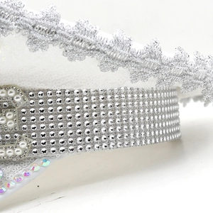 Detail of white party hat featuring sequins, lace embroidery and rhinestone crystal trim