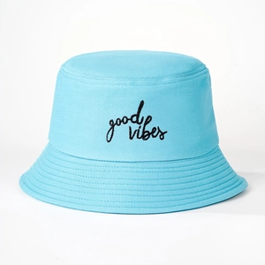 Detail of light blue cotton bucket hat with black Good Vibes embroidery texture