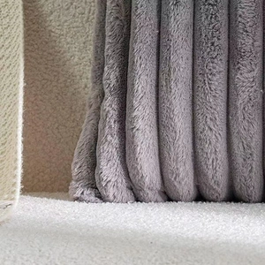 Close-up of grey faux rabbit fur pillow showing soft plush texture and striped pattern