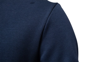 Detailed close-up of ribbed shoulder stitching on dark blue cotton sweatshirt fabric